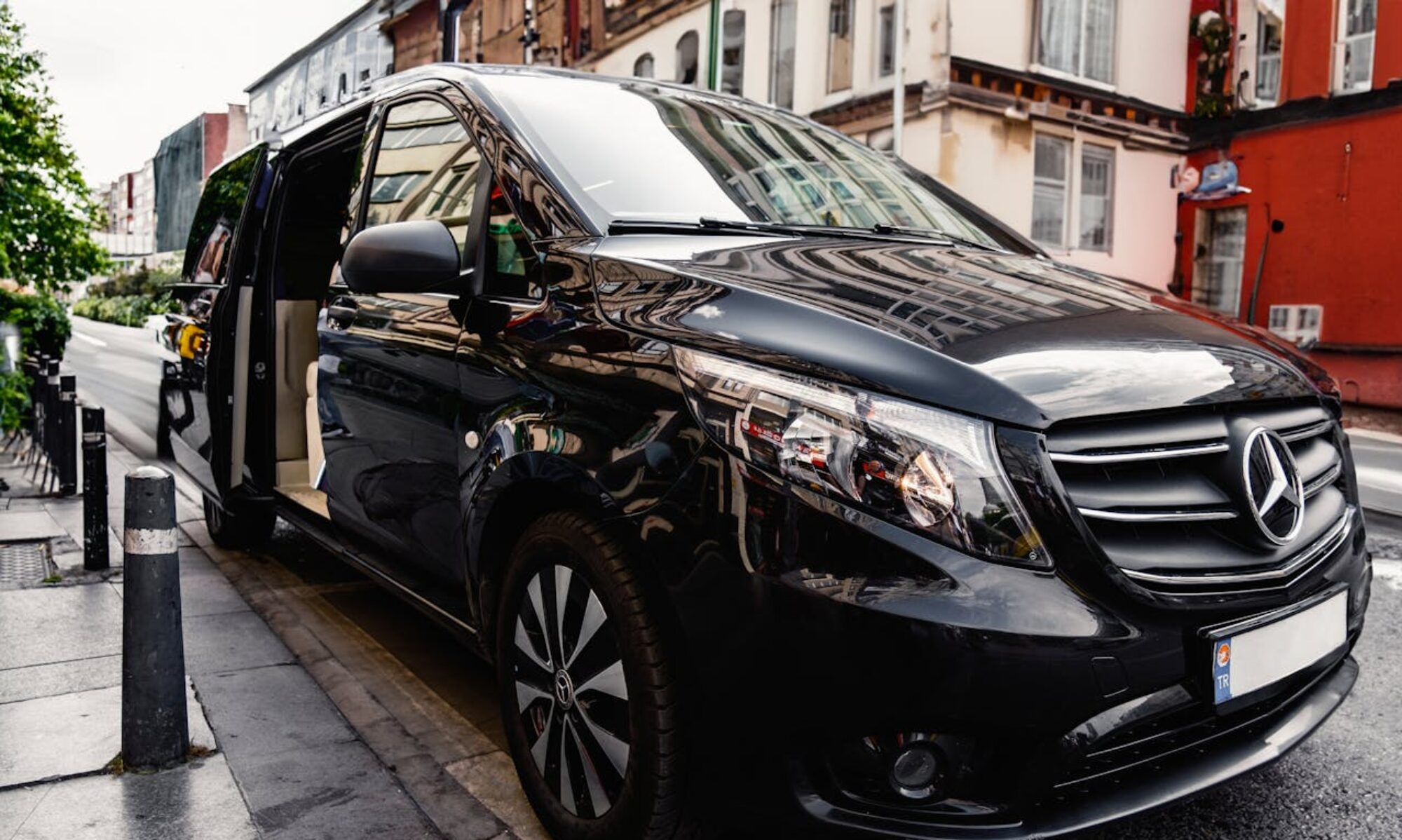 A stylish black Mercedes-Benz van parked on a bustling city street, showcasing luxury and modern design.